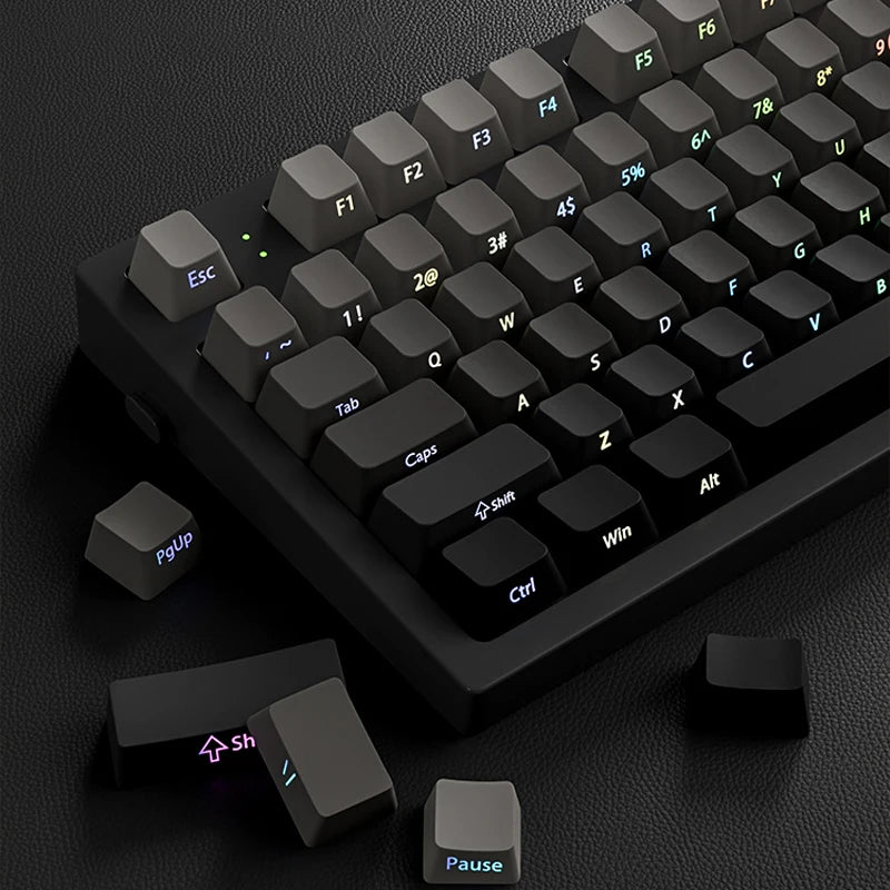 A close-up view of a black mechanical keyboard with gradient gray double shot PBT keycaps and side printing, showing various 