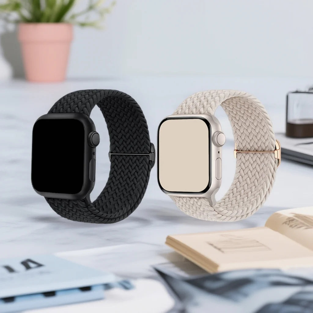 A black braided loop watch band and a beige braided loop watch band for Garmin devices are displayed on a white surface.