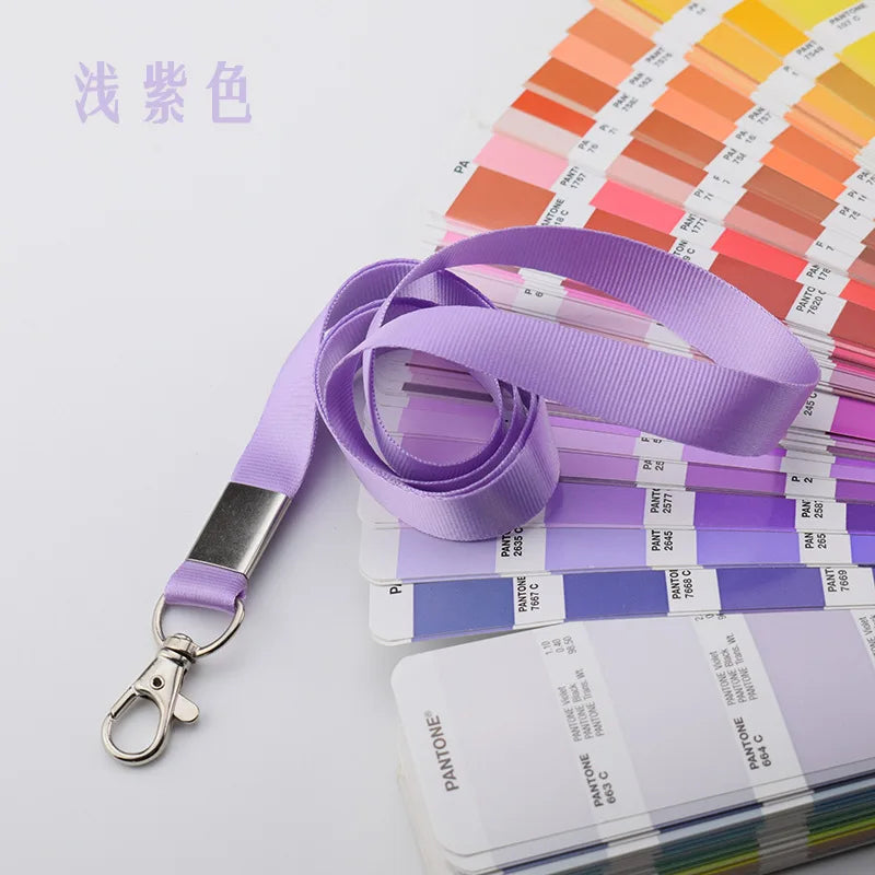 Porta credenciales resistente morado con dije plateado y muestras de color al fondo.