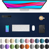 A large dark blue desk mat featuring various color circles and a laptop, keyboard, mouse, and a cup.