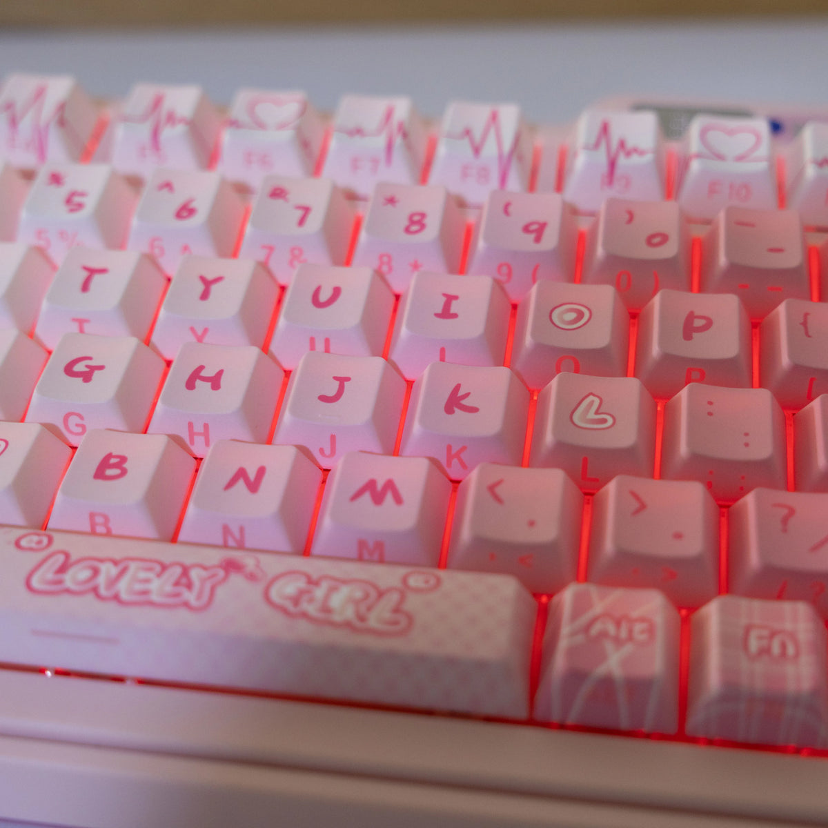 A close-up view of a translucent pink PBT keycap set for mechanical keyboards with various letter and number keys.