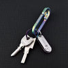 A compact stainless steel pocket knife attached to a keychain with a green and silver clasp.