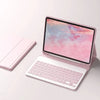 A pink detachable wireless keyboard folio case for an iPad, showing the tablet screen with a colorful sunset background.