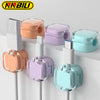 A collection of magnetic cable management clips in various pastel colors mounted on a white surface.