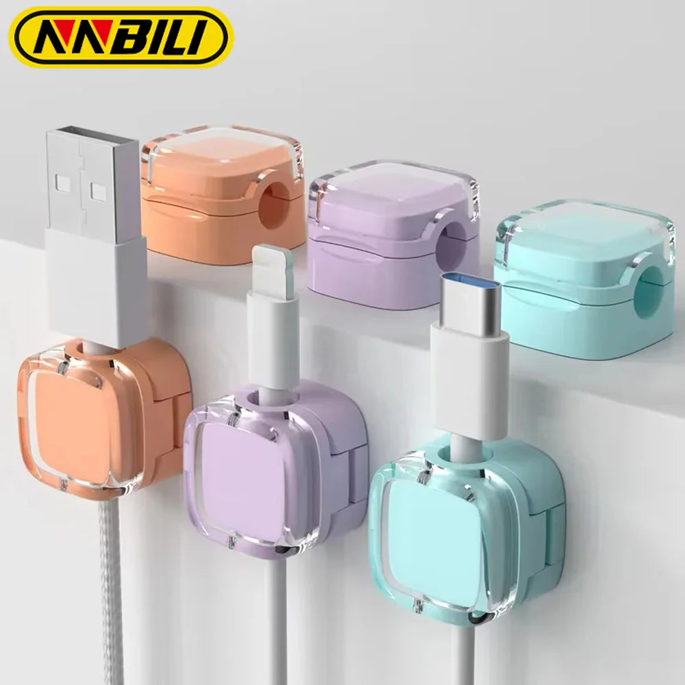 A collection of magnetic cable management clips in various pastel colors mounted on a white surface.