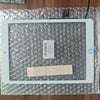 A white iPad screen is shown on a clear plastic sheet with a small card and a pink piece of paper.