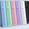 A row of colorful portable manual paper cutters or trimmers in various shades including blue, green, pink, and purple.