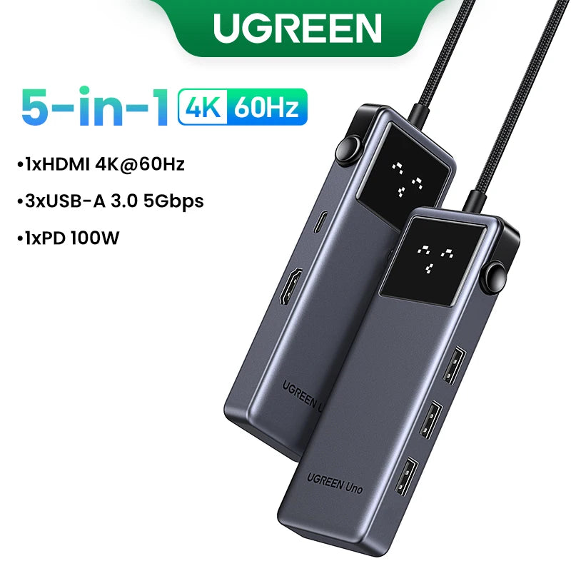 A black UGREEN 5-in-1 hub featuring an HDMI port, three USB-A ports, and a PD 100W charging output.