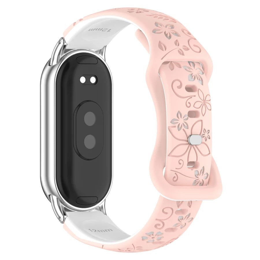 A pink silicone watch band with engraved flowers and a silver casing is shown on a white background.