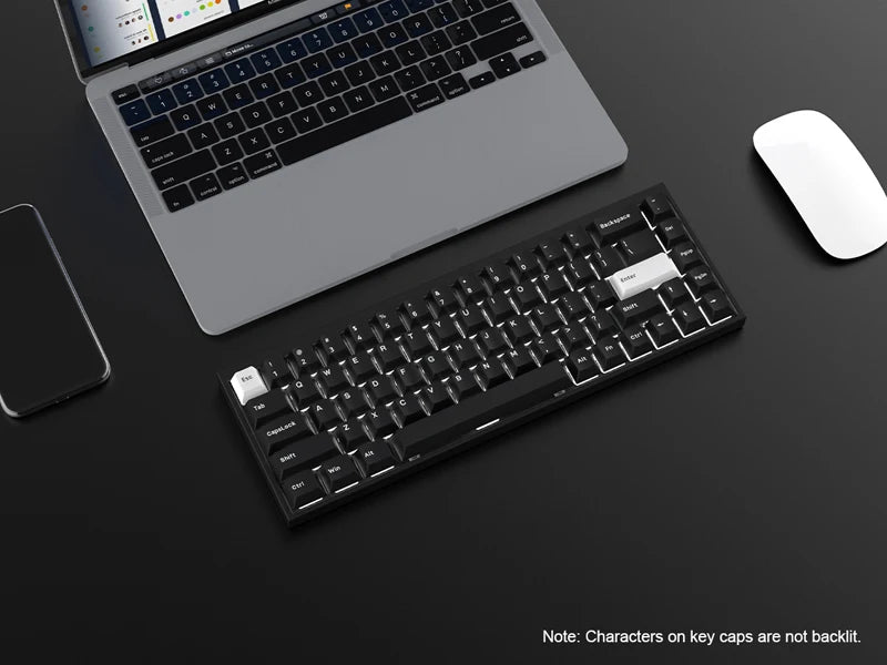 A close-up view of a laptop, keyboard, and mouse on a dark surface with PBT keycaps visible.