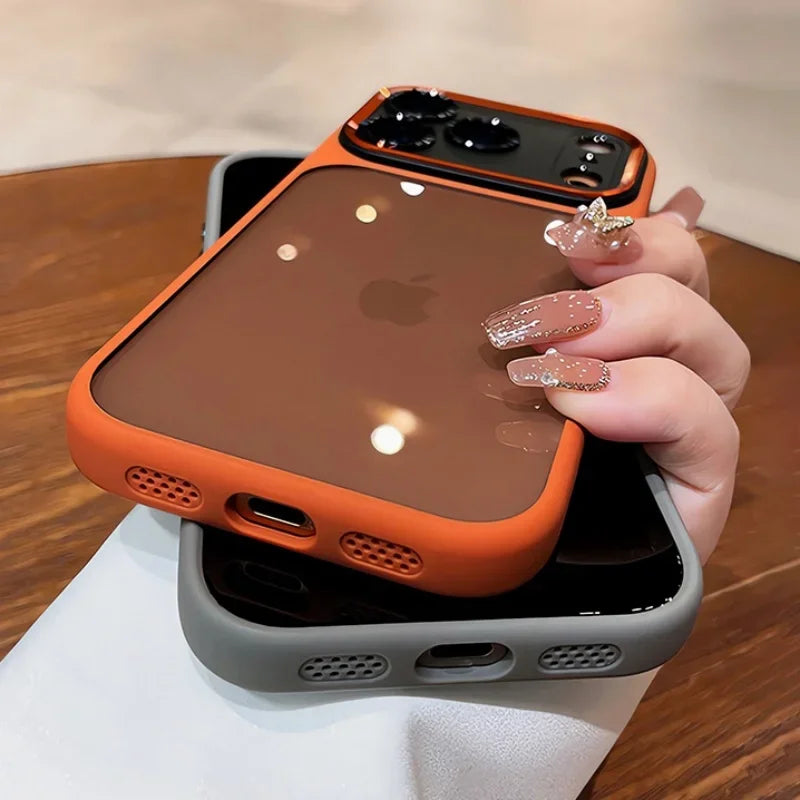 An orange clear shockproof case with camera lens protection for an iPhone is shown resting on a white surface.