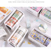 A set of colorful decorative transparent washi tape rolls in various shades and patterns displayed in open boxes.