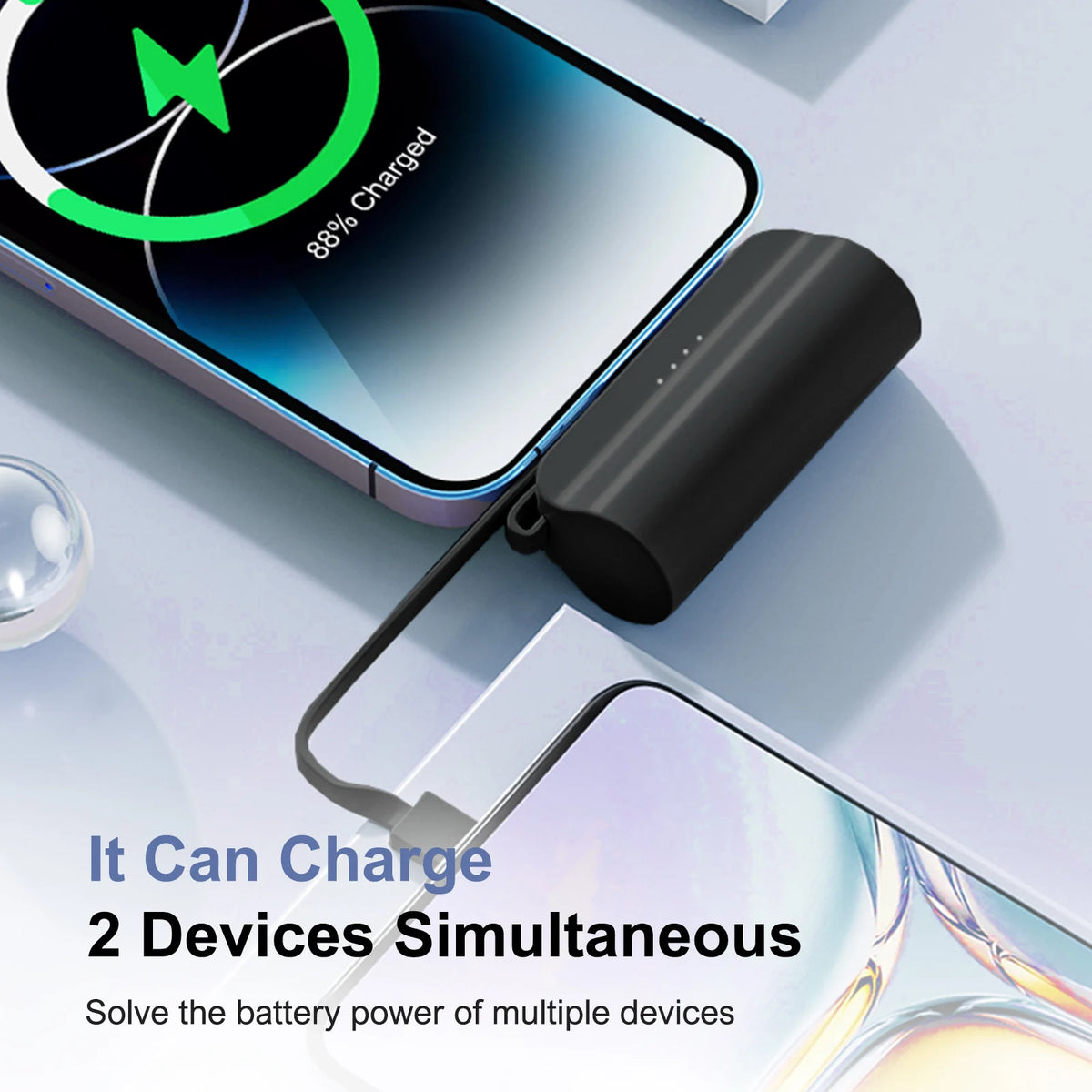 A black power bank is shown charging a smartphone, illustrating its ability to charge two devices simultaneously.
