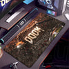 حصيرة مكتب ألعاب داكنة بتصميم ظلام Doom معروضة على سطح مكتب أسود.