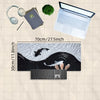 A gaming mouse pad featuring a black and white koi fish pattern, shown next to a laptop and headphones.