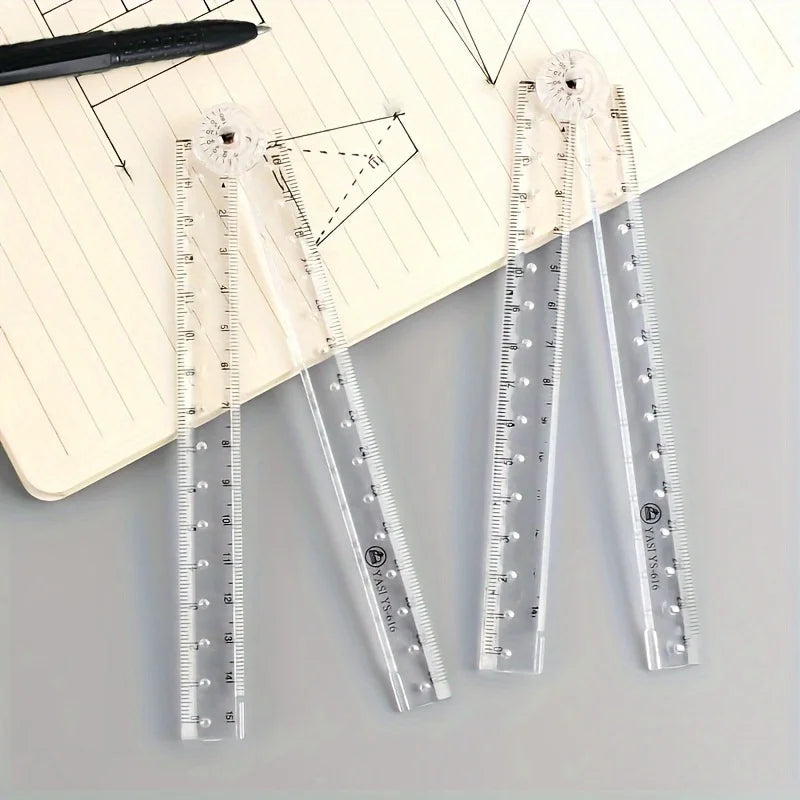 Tres reglas plegables de acrílico transparente con pompones blancos decorativos, exhibidas sobre un cuaderno rayado.