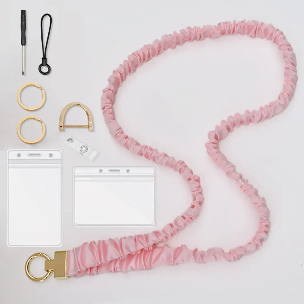 Pink stretchy breakaway ID badge lanyard with a gold-tone retractable reel and various accessories