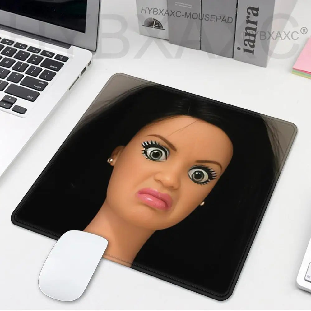 A playful doll face desk mouse pad with a realistic painted face and a white mouse underneath.