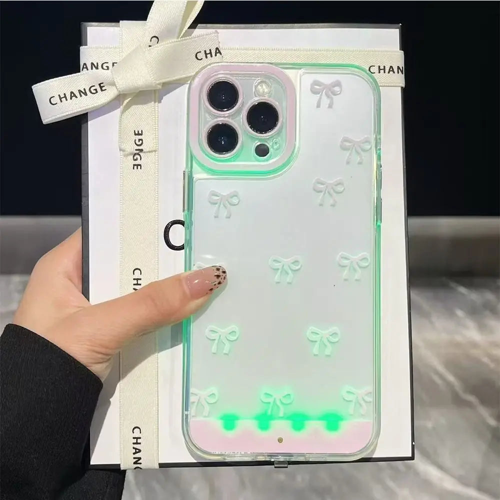 A hand holds an LED bowknot glow case for an iPhone, displaying a light show effect.