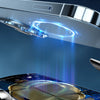 Close-up view of a silver wireless car phone mount with blue light emanating from the charging area.