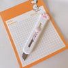 A white cat paw mini cutter is shown on a grid paper sheet with title and content lines.