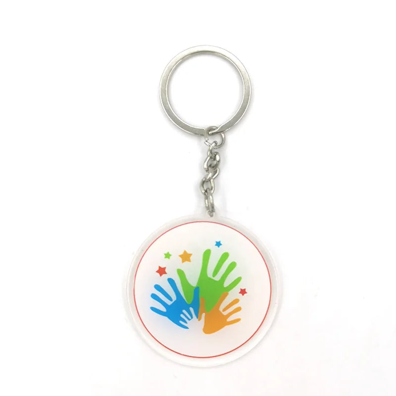 Silberner Schlüsselanhänger mit kreisrunder Anhänger, der eine bunte Handabdruck-Motiv zeigt.