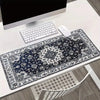 A vintage Persian rug patterned gaming mouse pad with a non-slip rubber base is displayed on a white desk.