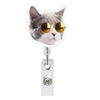 A cat wearing round gold sunglasses is attached to a clear ID badge holder with a crocodile clip.