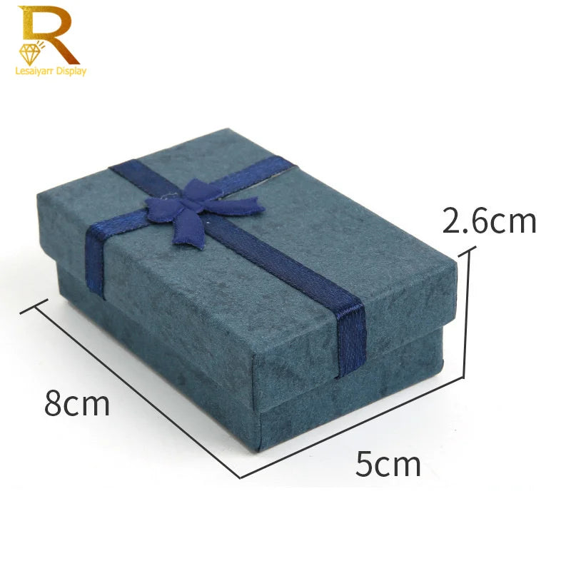 A rectangular dark blue velvet jewelry gift box with a navy ribbon, shown from above.