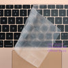 Una funda de teclado de silicona transparente apoyada sobre un teclado de portátil beige.