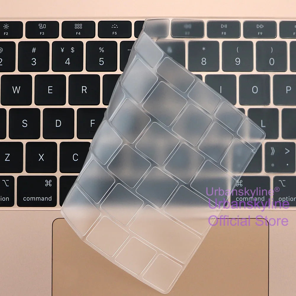 Una funda de teclado de silicona transparente apoyada sobre un teclado de portátil beige.