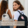A young woman holds a black backpack with a pink keychain attached to the strap.
