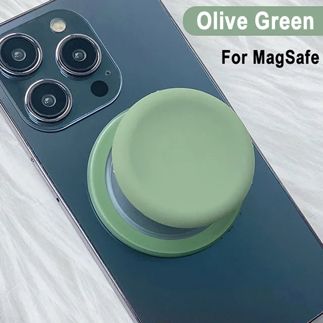 Olive green silicone cover for a MagSafe phone grip stand on a dark blue smartphone.