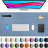 A large PU leather desk mat is shown with a computer monitor, keyboard, mouse, and smartphone on a light blue surface.