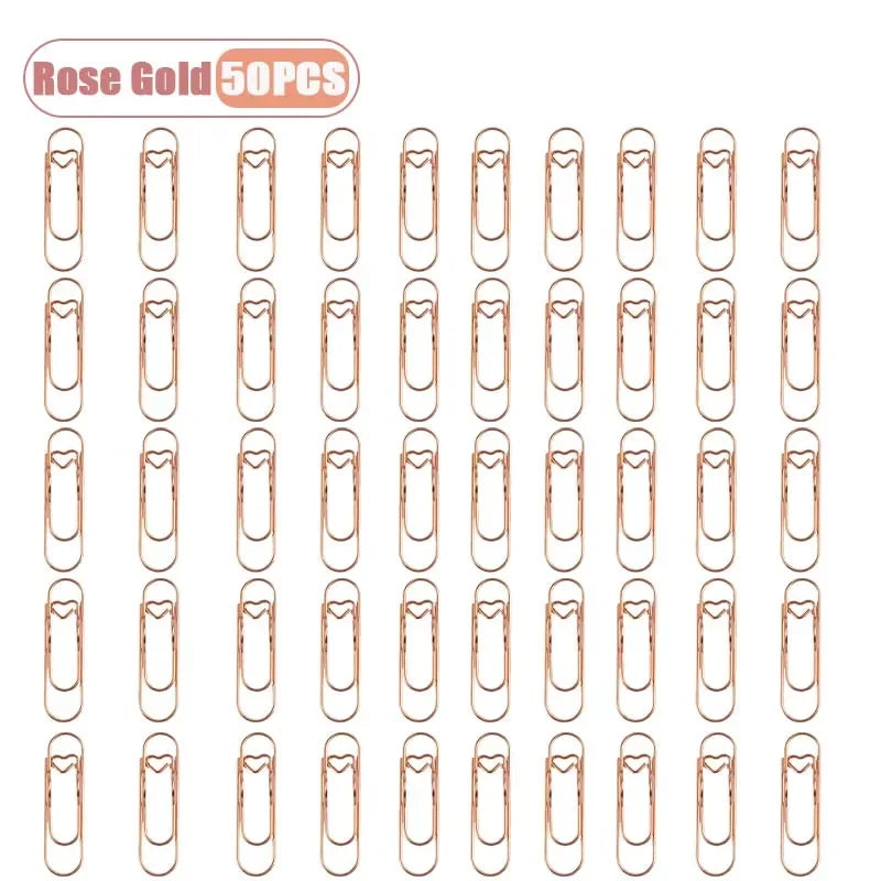 A set of rose gold metal pen clips designed for securing pages in notebooks and journals.