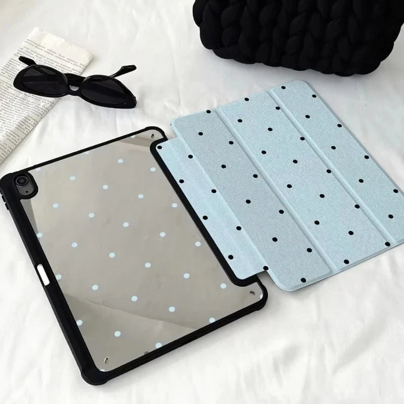 A black acrylic protective skin for an iPad case is shown next to sunglasses and a dark fabric.