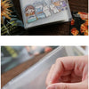 A clear photo storage booklet featuring cute illustrations of girls and animals.