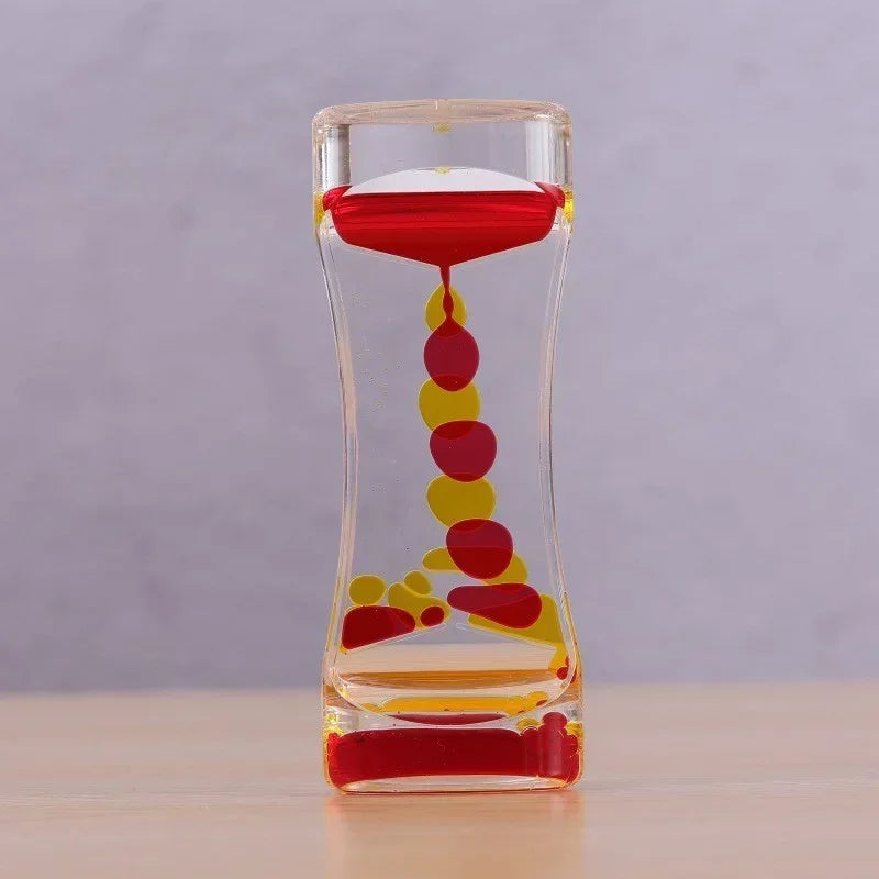 A glass hourglass filled with colored liquid, showing a slow flow of red and yellow liquids.