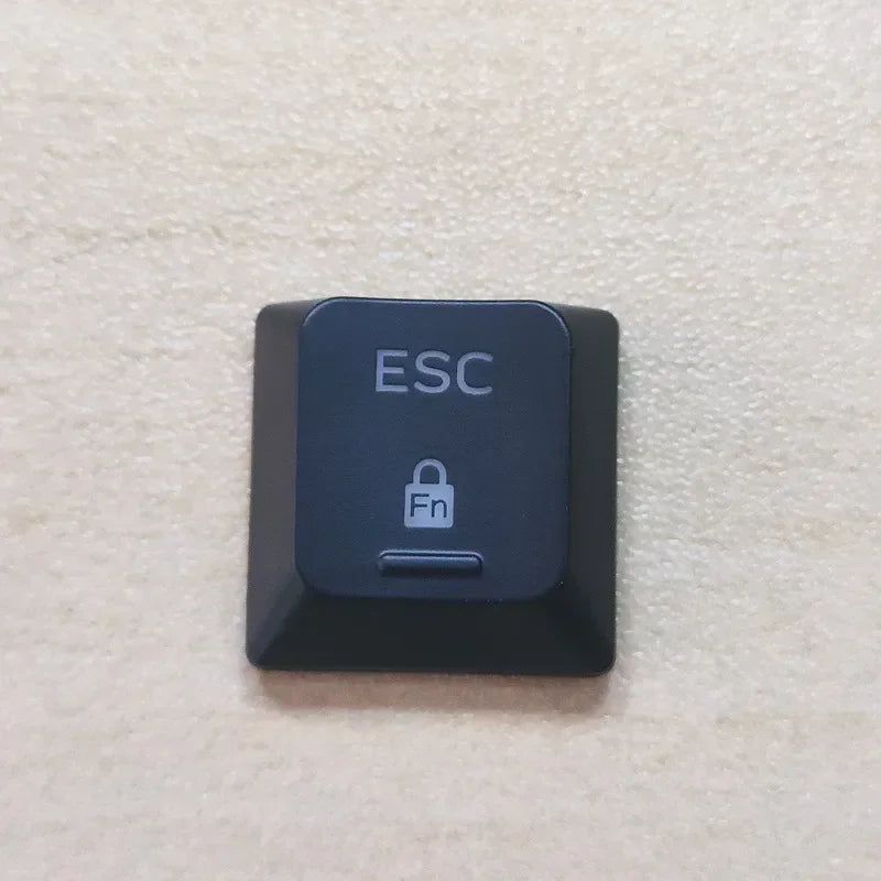 A black electronic device labeled ESC with a lock icon and a button on a light beige surface.