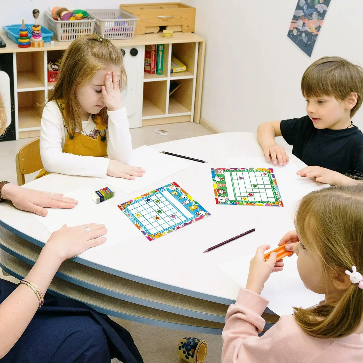 A group of children are using an incentive reward chart for behavior tracking on a table.