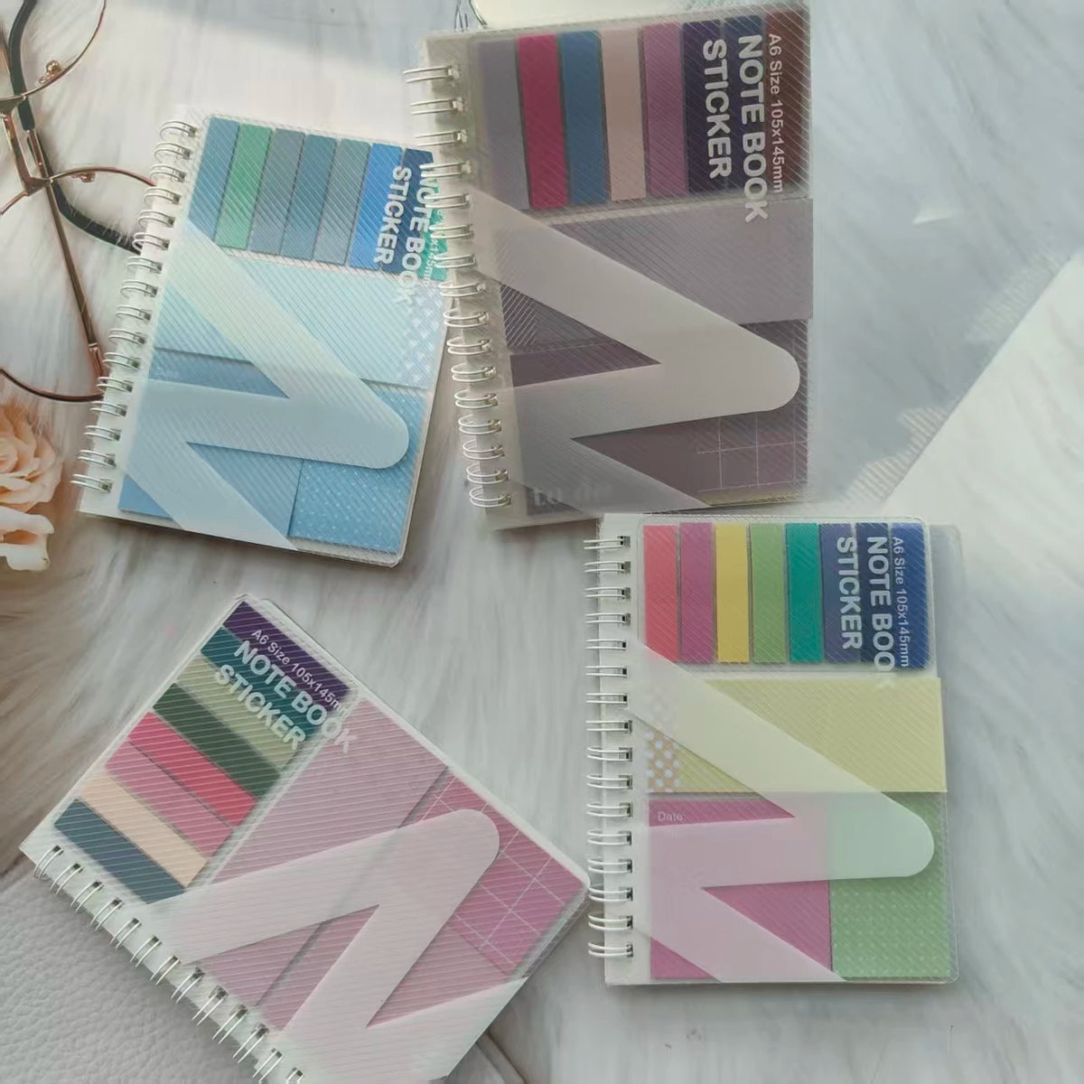 A collection of colorful A6 sticky note notebooks with loop closures and various pastel shades.