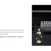 A close-up view of a black mechanical keyboard with custom switches and stabilizers on a dark surface.