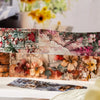 A close-up of decorative watercolor floral washi tape featuring pink, orange, and green botanical designs.