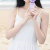 A woman holds a purple portable cooling engine fan near her neck, demonstrating instant cooling sensation.