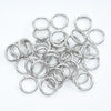 A collection of small, colorful spring clasps and rings arranged on a white background.