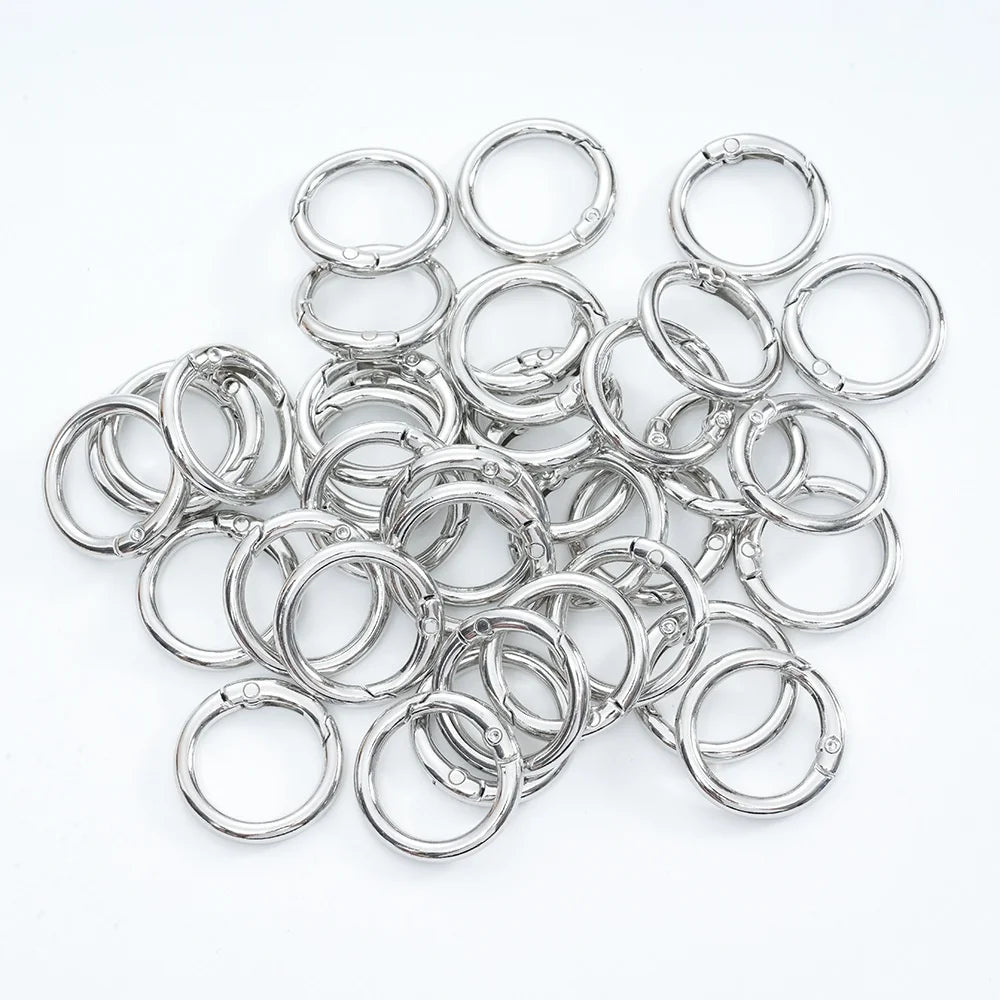 A collection of small, colorful spring clasps and rings arranged on a white background.