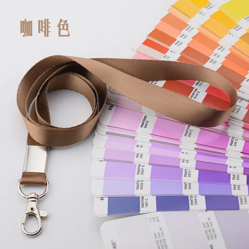 Porta credencial resistente marrón con cordón y muestras de colores Pantone en fondo blanco.