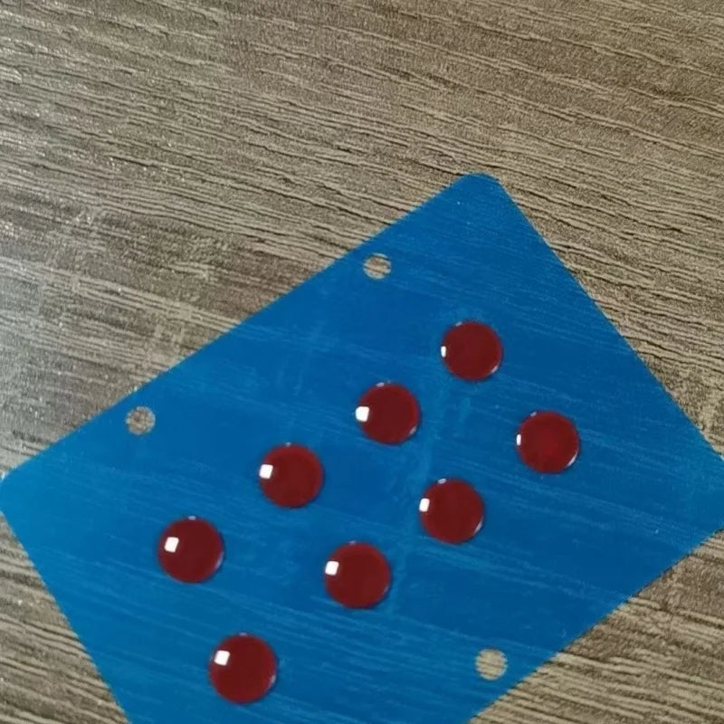 Blue acrylic mouse skates with red dots placed on a wooden surface.