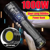 A hand holds a black tactical LED flashlight with adjustable zoom and visible COB tail lights.