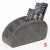 A gray PU leather caddy organizer holding three black TV remotes.